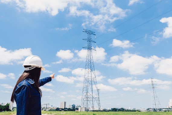 1-senhora-no-capacete-de-seguranca-apontando-para-linha-de-alta-tensao