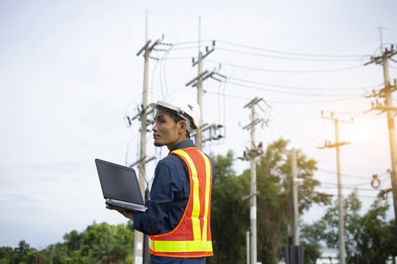 Engineering Holding Notebook inspects the wires on the electrical pole.